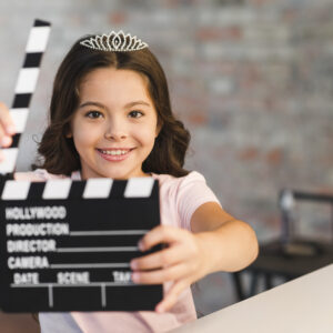 smiling-beautiful-girl-holding-clapperboard